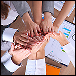 Business team with hands together – teamwork concepts