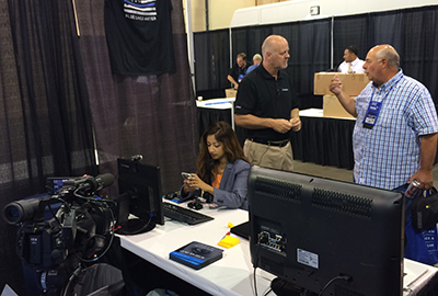 ABC 4 Utah TV Reporter Tasmin Mahfuz (left) prepares her news segment while Converus VP of Worldwide Sales Neal Harris (center) discusses the EyeDetect technology with Sheriff James O. Tracy, president of the Utah Sheriff’s Association, at the 20th Annual Corrections and Law Enforcement Training Conference in St. George, Utah.